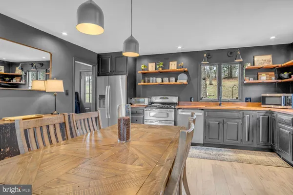 a dining room with furniture a chandelier and wooden floor