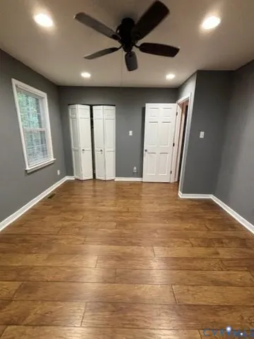 a view of an empty room with window and wooden floor