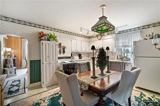 a kitchen with stainless steel appliances granite countertop a refrigerator dining table and chairs