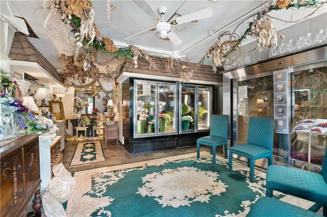 a room with lots of white furniture and a chandelier