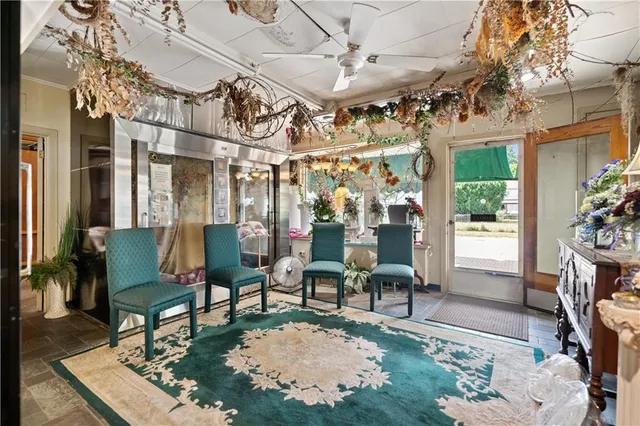 a living room with patio furniture and a chandelier