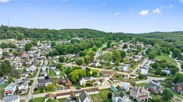 an aerial view of residential houses with outdoor space and trees