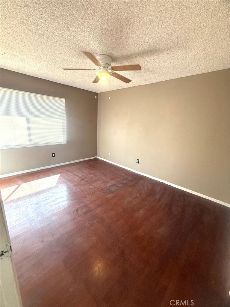 495 West 13th Street Perris, CA 92570 - Photo 17 of 32 an empty room with a window and a ceiling fan