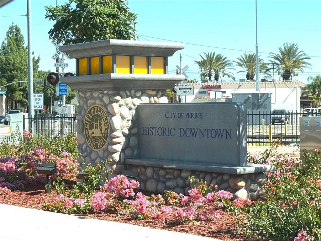 495 West 13th Street Perris, CA 92570 - Photo 2 of 32 a sign that is in front of flowers