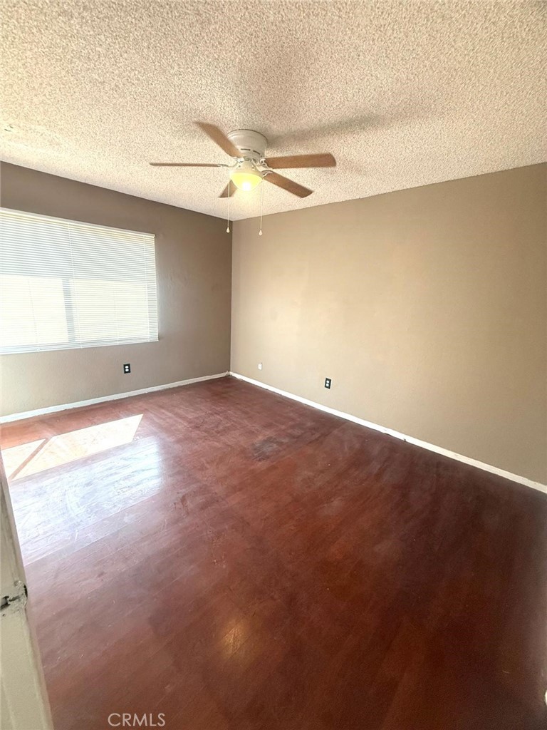 495 West 13th Street Perris, CA 92570 - Photo 24 of 32 an empty room with a window and a ceiling fan