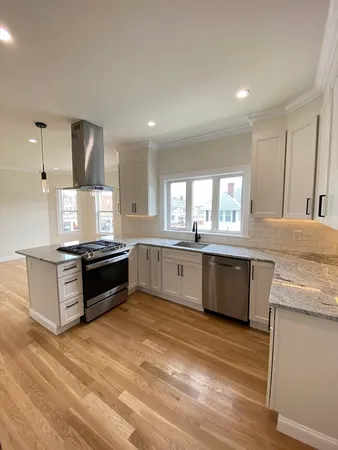 a large kitchen with stainless steel appliances kitchen island granite countertop a stove a sink and a microwave