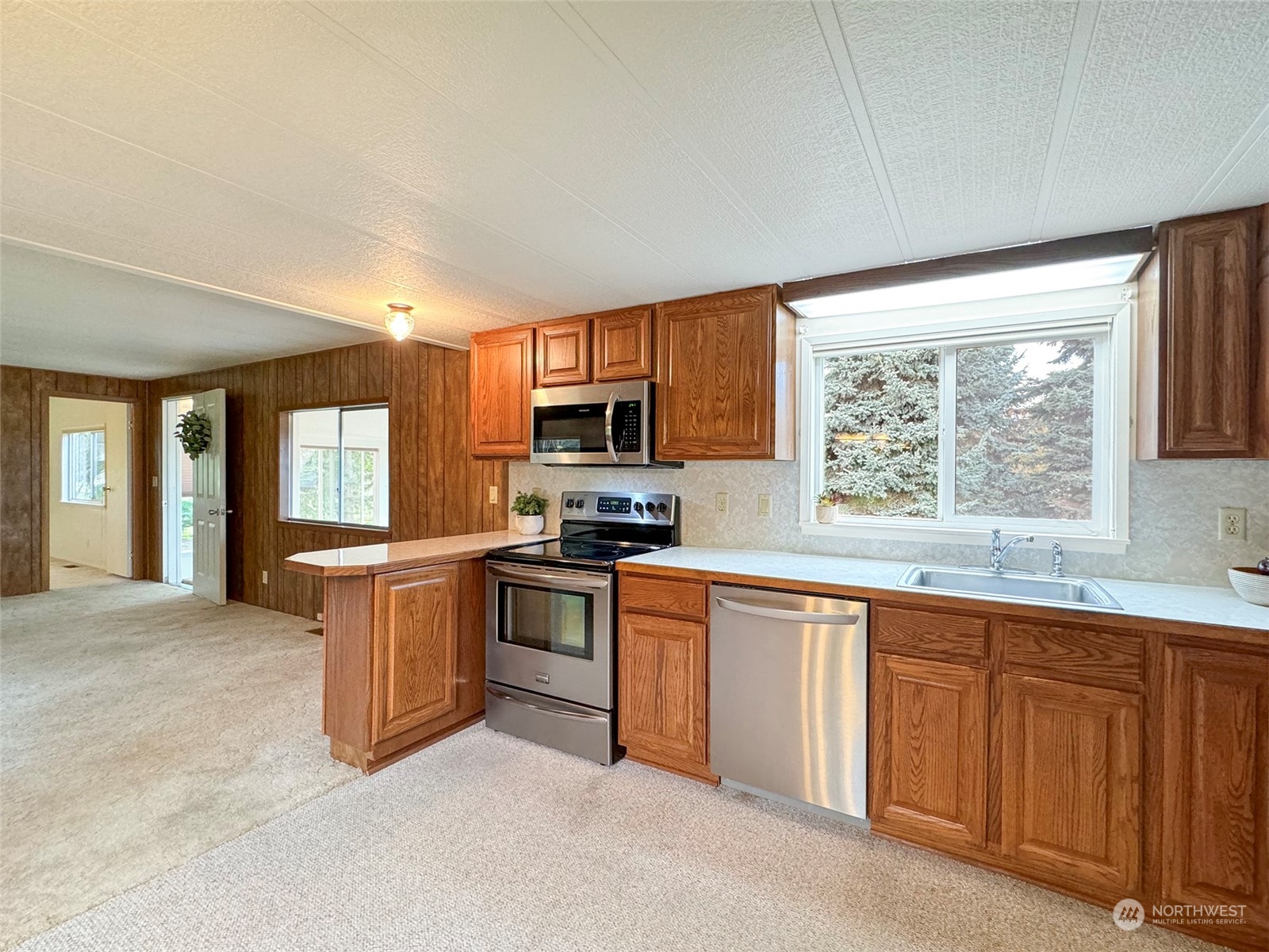 241 Evans Road Sequim, WA 98382 - Photo 12 of 40 a kitchen with granite countertop a stove sink and microwave
