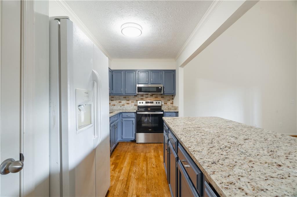 1307 Whitlock Ridge Drive Marietta, GA 30064 - Photo 12 of 29 a kitchen with stainless steel appliances granite countertop a stove a sink and a refrigerator