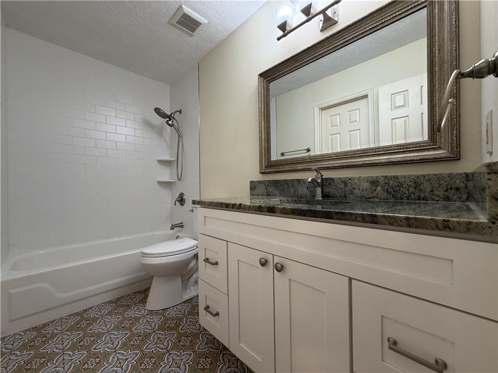 1307 Whitlock Ridge Drive Marietta, GA 30064 - Photo 18 of 29 a bathroom with a toilet a sink and bathtub