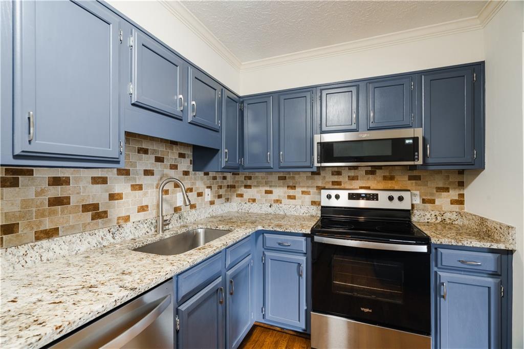 1307 Whitlock Ridge Drive Marietta, GA 30064 - Photo 6 of 29 a kitchen with stainless steel appliances granite countertop a sink stove and microwave
