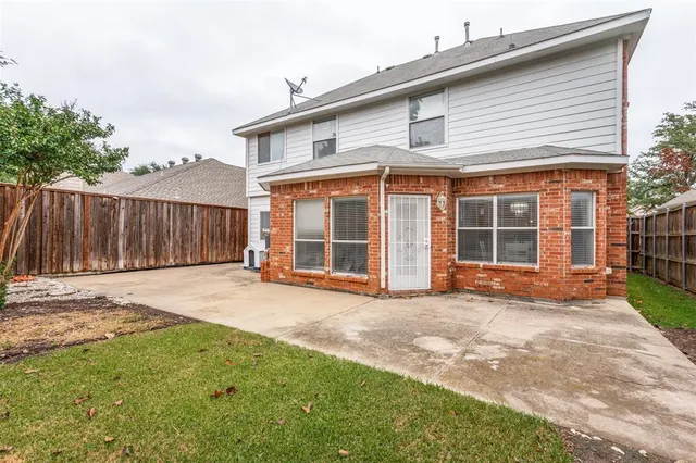 a view of a house with backyard and wooden fence