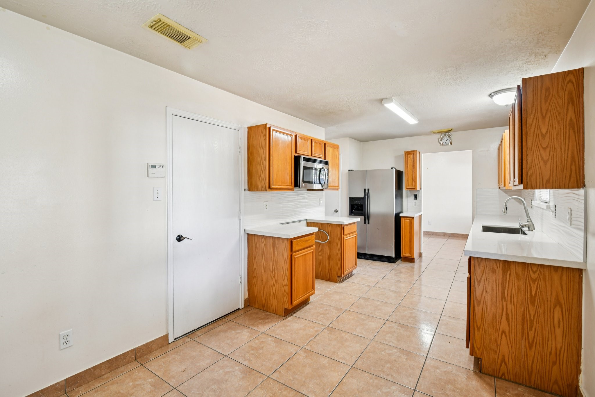 12270 Cobbs Creek Road Houston, TX 77067 - Photo 15 of 42 a large kitchen with stainless steel appliances a sink and cabinets