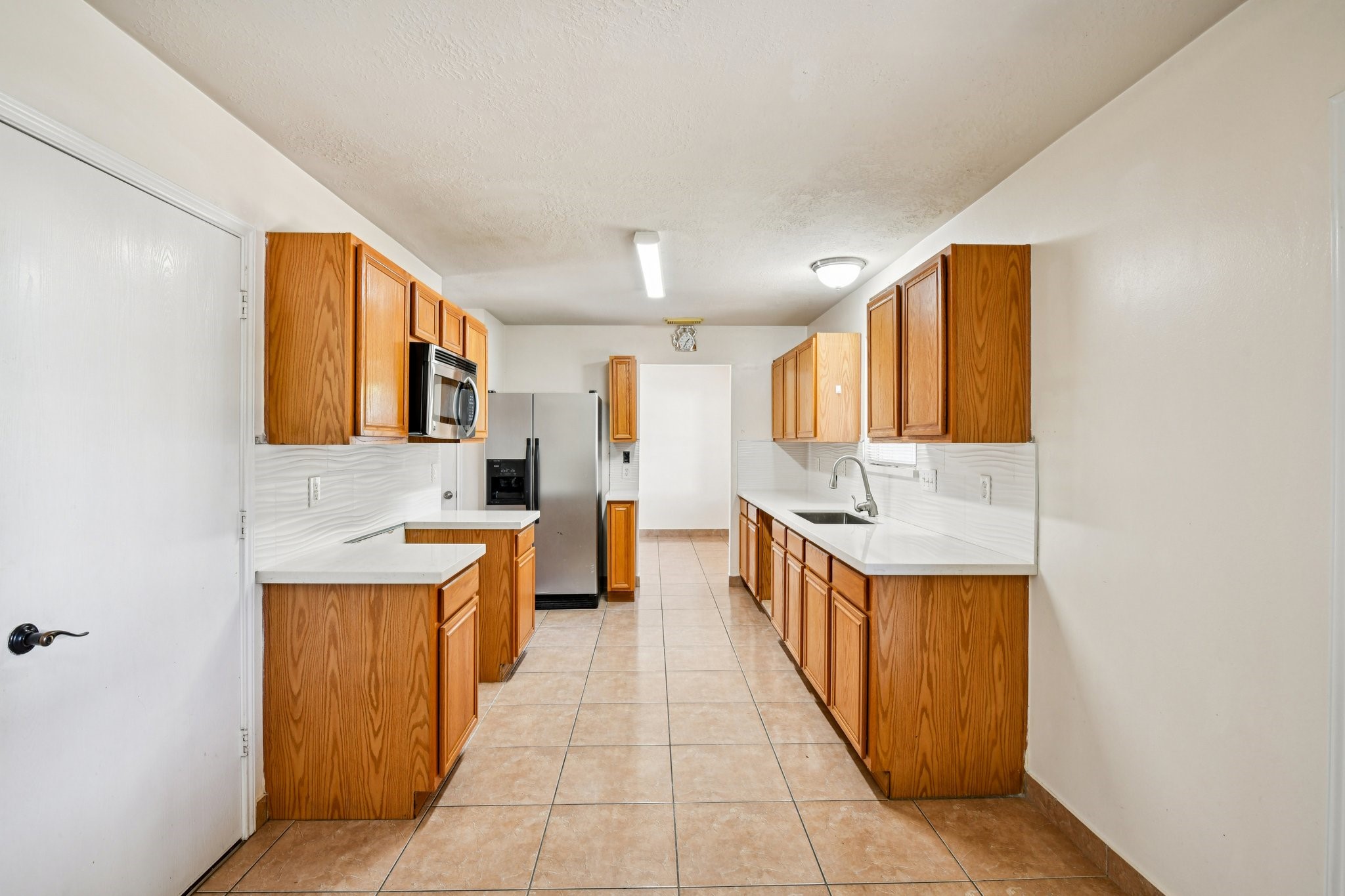 12270 Cobbs Creek Road Houston, TX 77067 - Photo 16 of 42 a large kitchen with stainless steel appliances a sink and cabinets