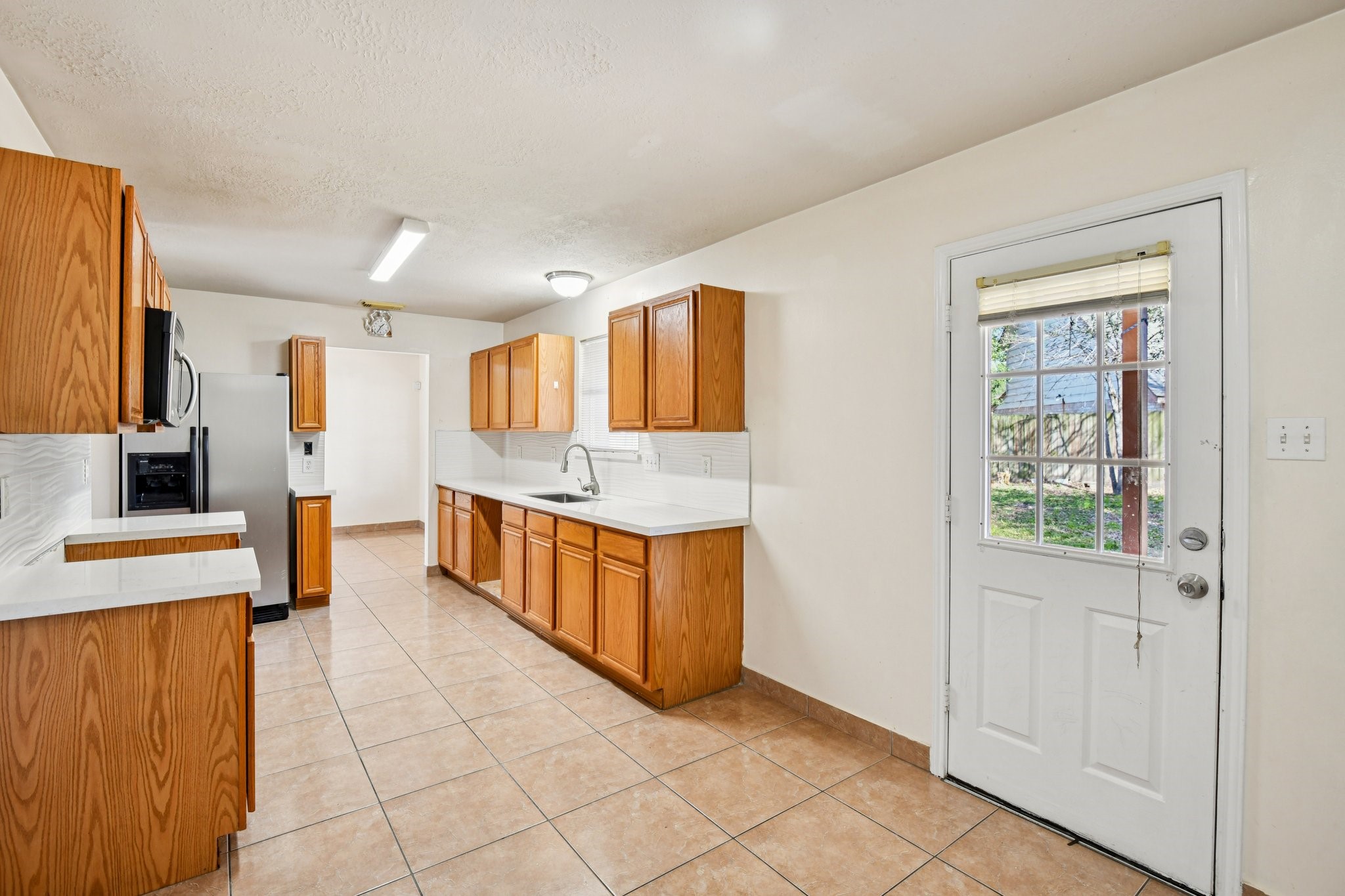 12270 Cobbs Creek Road Houston, TX 77067 - Photo 17 of 42 a large white kitchen with stainless steel appliances kitchen island granite countertop a refrigerator and a stove top oven