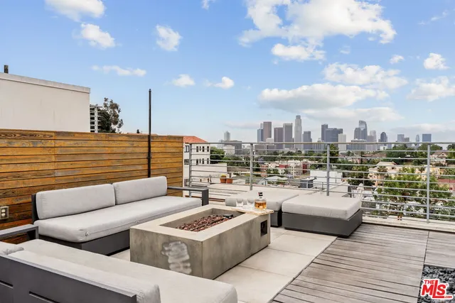 a view of a roof deck with couches and potted plants