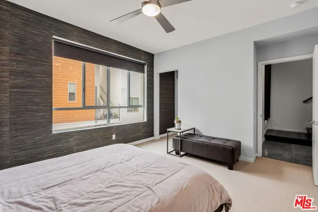 a bedroom with a bed and a large window