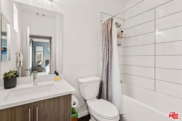 a bathroom with a sink toilet vanity and shower