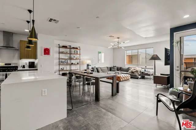 a living room with furniture a flat screen tv and a table