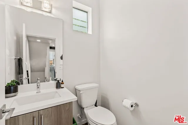 a bathroom with a sink a toilet and mirror