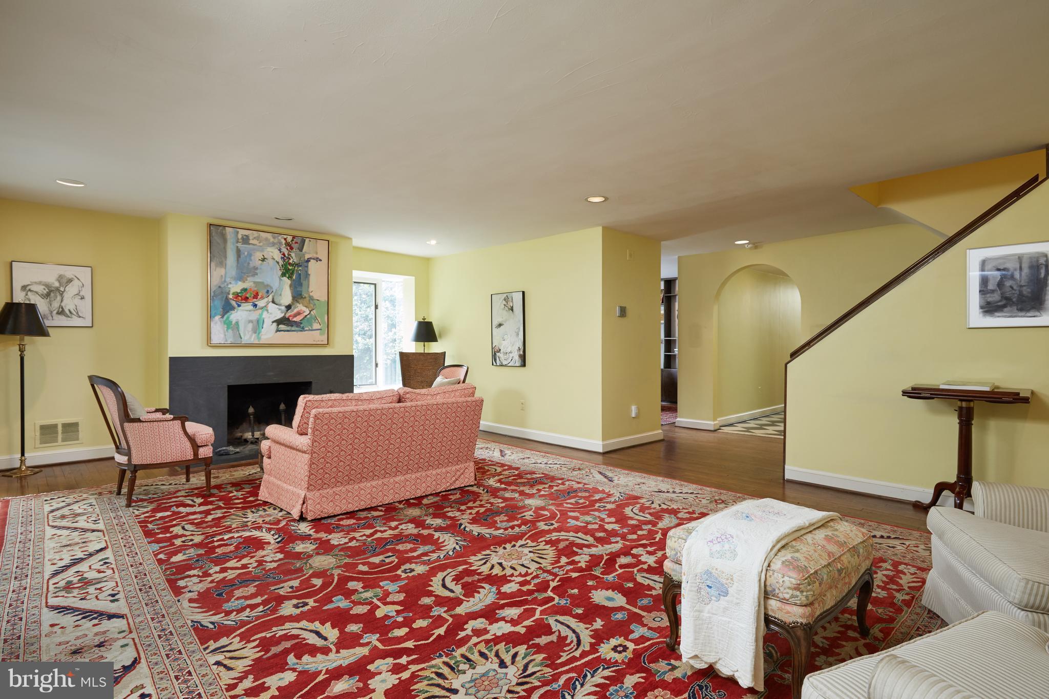 3033 West Ln Keys Northwest Washington, DC 20007 - Photo 18 of 30 a living room with furniture a fireplace and a painting on the wall