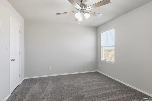 an empty room with a window and a fan