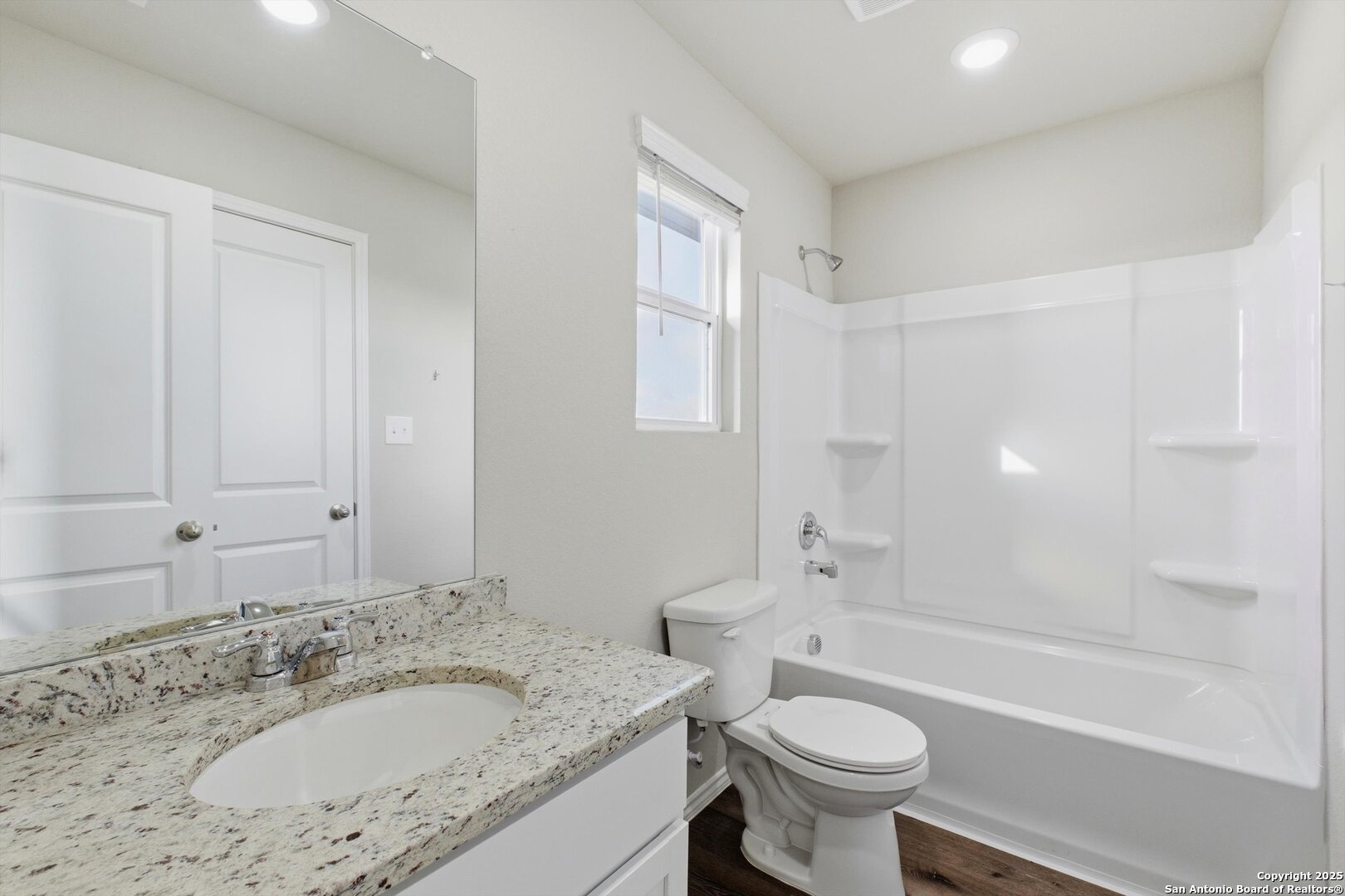 514 Abigail Alley San Antonio, TX 78253 - Photo 12 of 17 a bathroom with a granite countertop sink a toilet a mirror and bathtub