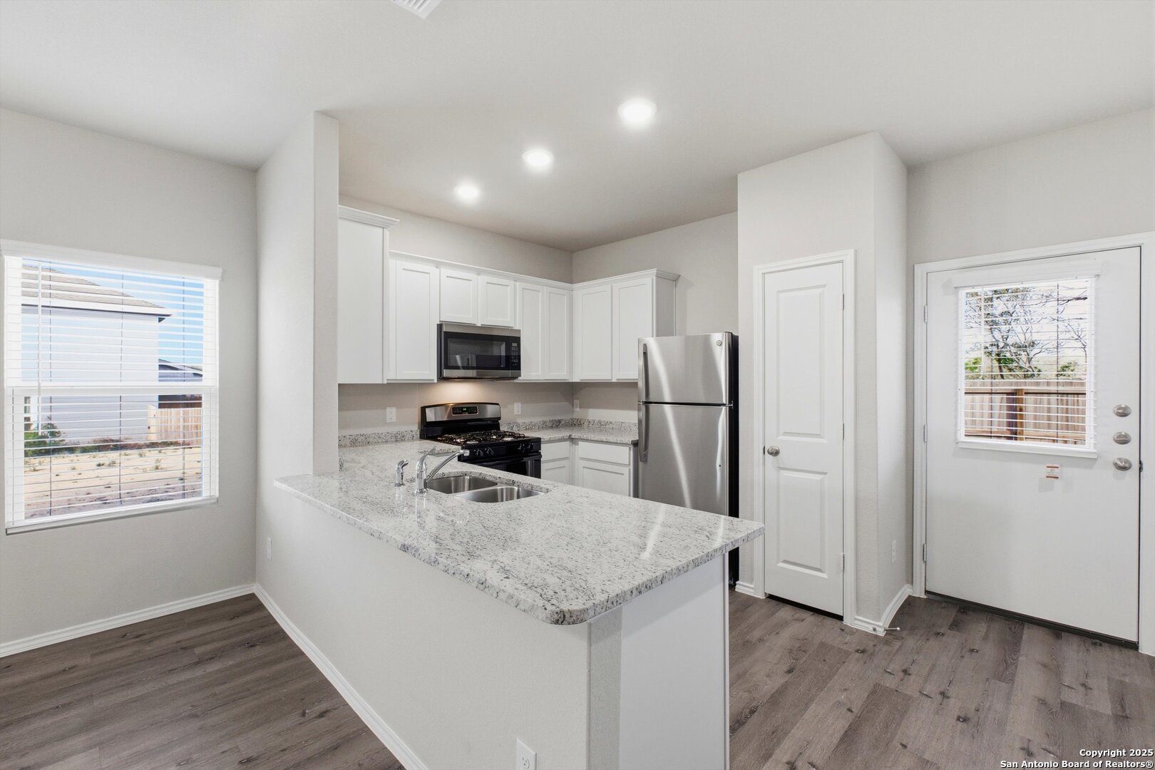 514 Abigail Alley San Antonio, TX 78253 - Photo 4 of 17 a kitchen with stainless steel appliances granite countertop a refrigerator oven a sink dishwasher and wooden floor