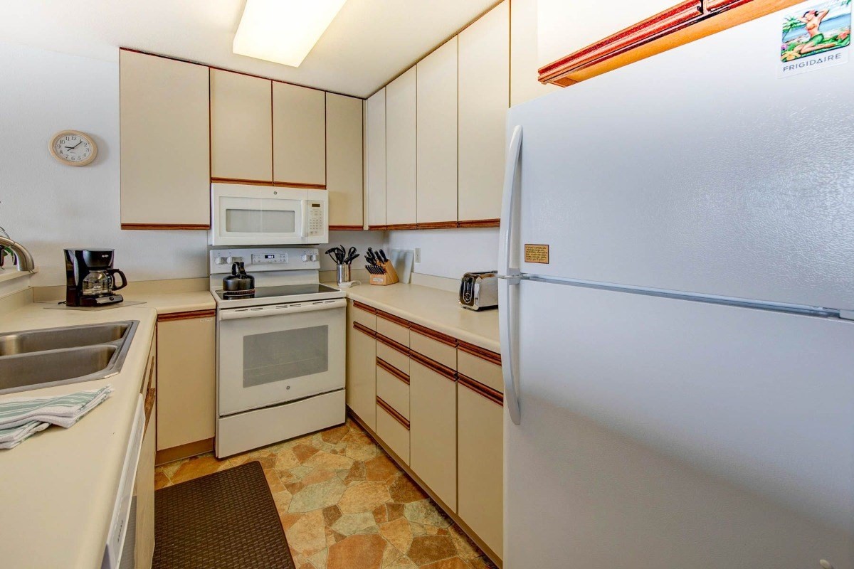 320 Papaloa Road, Unit 213 Kapaa, HI 96746 - Photo 16 of 25 a kitchen with a sink cabinets stainless steel appliances and a counter top space