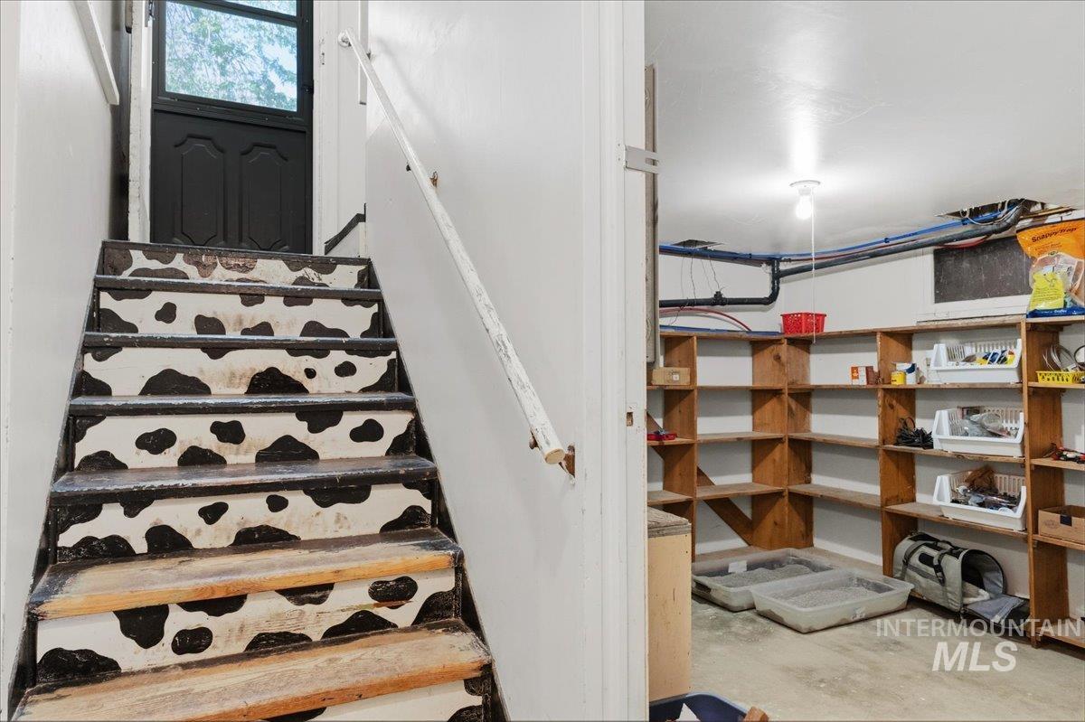 1958 East 1775 South Gooding, ID 83330 - Photo 31 of 49 Staircase featuring a distinctive black and white pattern on the risers, a white handrail, and a black exterior door with window