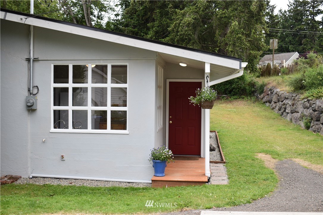 10411 Northeast West Kingston Road Kingston, WA 98346 - Photo 2 of 31 a front view of a house with garden