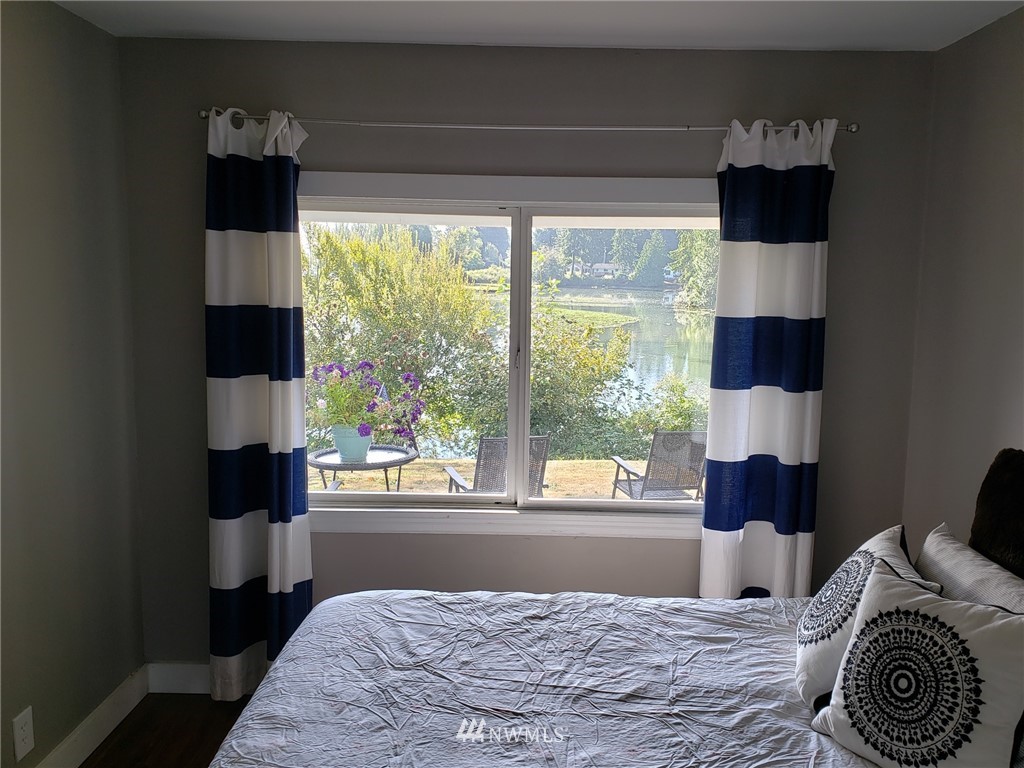 10411 Northeast West Kingston Road Kingston, WA 98346 - Photo 14 of 31 a bed sitting in a bedroom next to a window