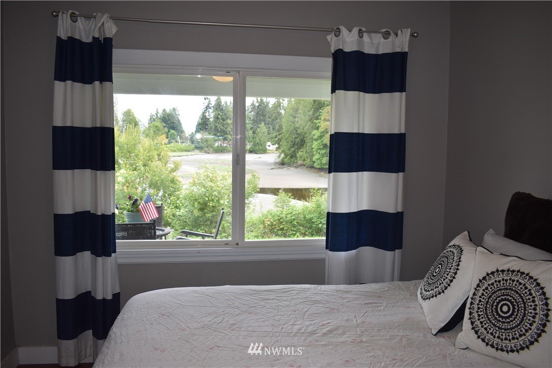 10411 Northeast West Kingston Road Kingston, WA 98346 - Photo 16 of 31 a bedroom with a large bed and a window