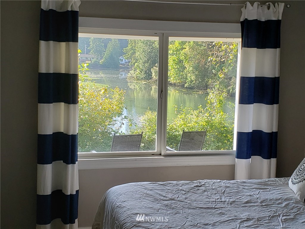 10411 Northeast West Kingston Road Kingston, WA 98346 - Photo 17 of 31 a bedroom with a large bed and a window