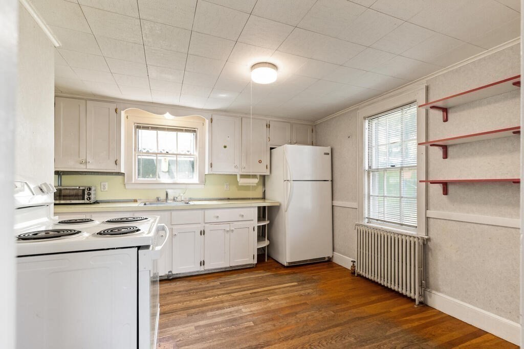 8 Florence Road Waltham, MA 02453 - Photo 13 of 33 a kitchen with a refrigerator a stove cabinets and wooden floor