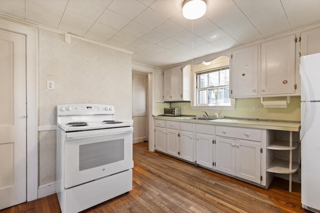 8 Florence Road Waltham, MA 02453 - Photo 14 of 33 a kitchen with granite countertop white cabinets and white appliances
