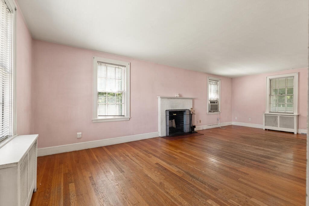 8 Florence Road Waltham, MA 02453 - Photo 6 of 33 an empty room with windows fireplace and wooden floor