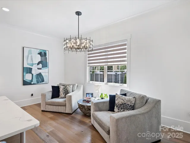 a living room with furniture and a chandelier