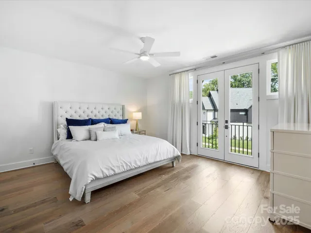 a bedroom with a large bed and a chandelier