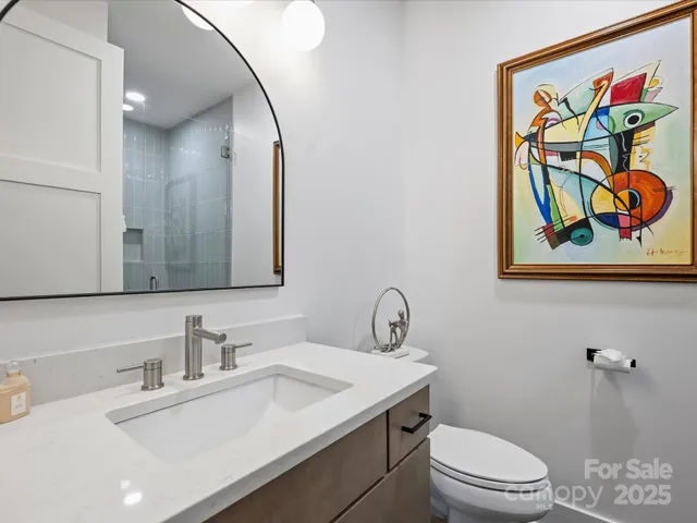 a bathroom with a toilet a sink and mirror