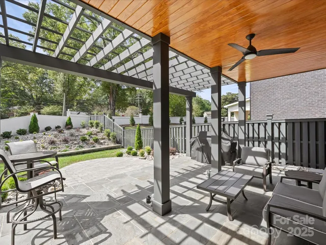 a view of a patio with table and chairs potted plants with wooden floor and fence