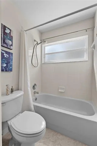 a white toilet sitting next to a bath tub and a shower