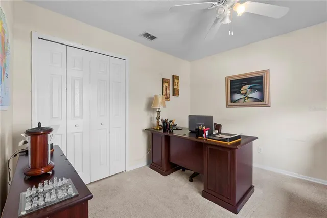 a view of a workspace with furniture and a window