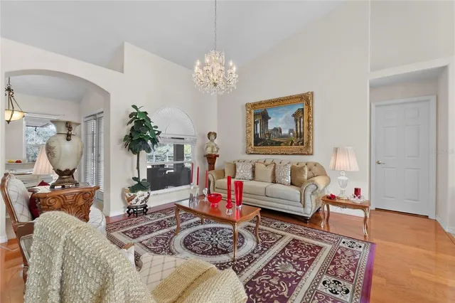 a view of a dining room with furniture a chandelier and wooden floor