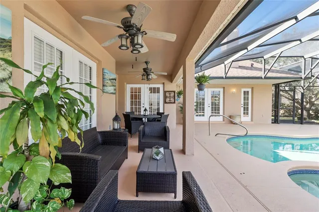 a living room with patio furniture and a potted plant
