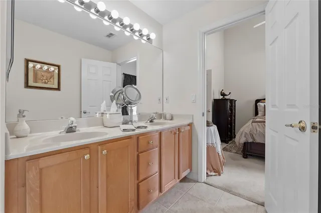 a en suite bathroom with a double vanity sink and a mirror