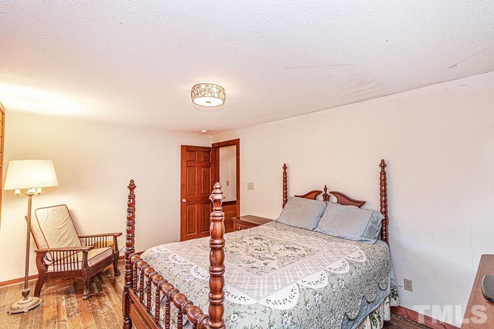 1409 Frazier Road Spring Hope, NC 27882 - Photo 11 of 28 a bedroom with a bed and a lamp on table