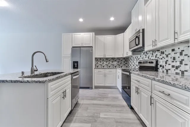 a view of an empty room with wooden floor and a bathroom
