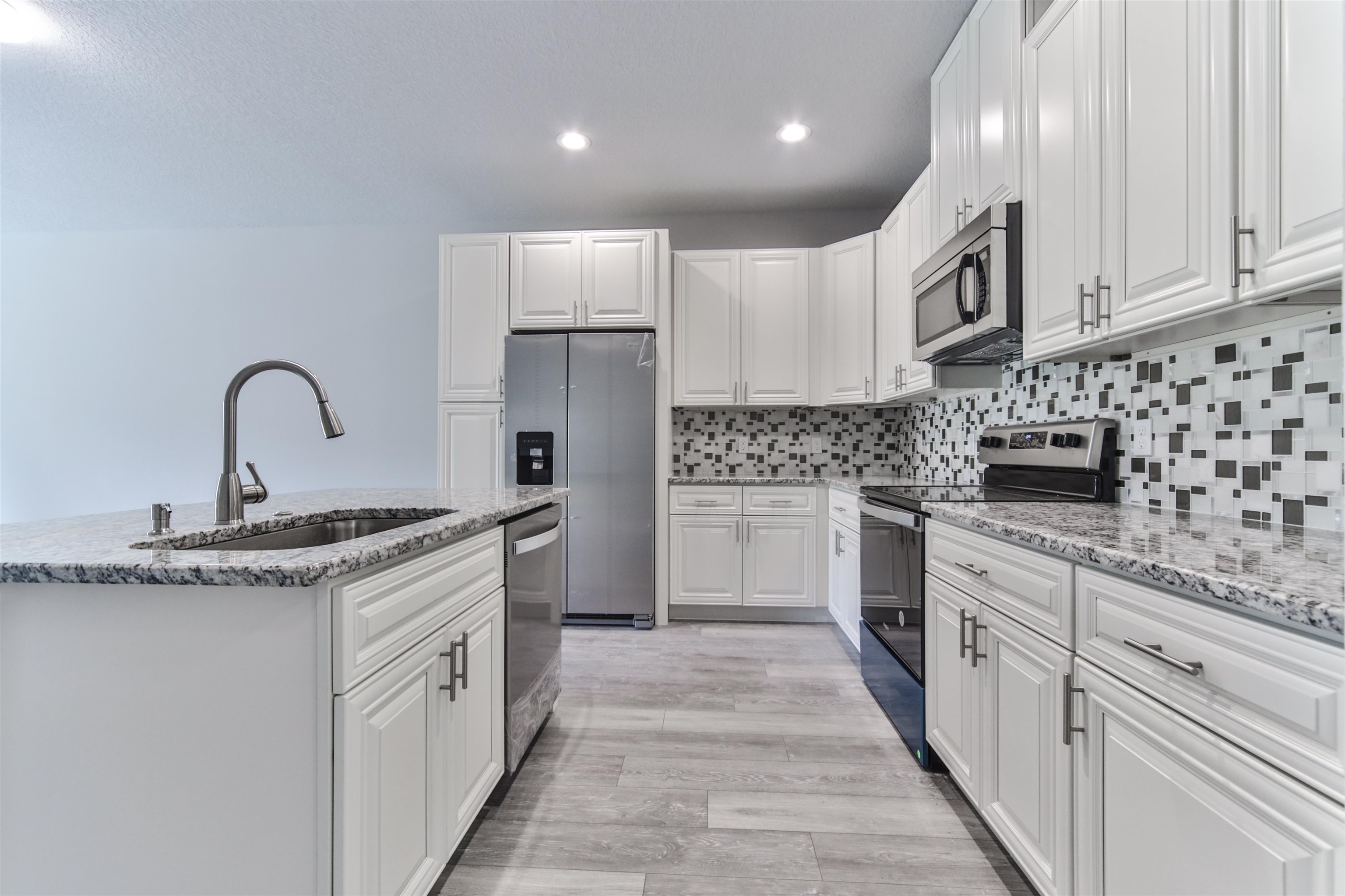 9 Seton Place Palm Coast, FL 32164 - Photo 19 of 37 a kitchen with granite countertop a sink stove and cabinets