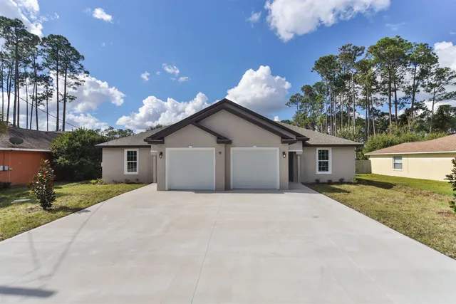 a view of a house with a yard and garage