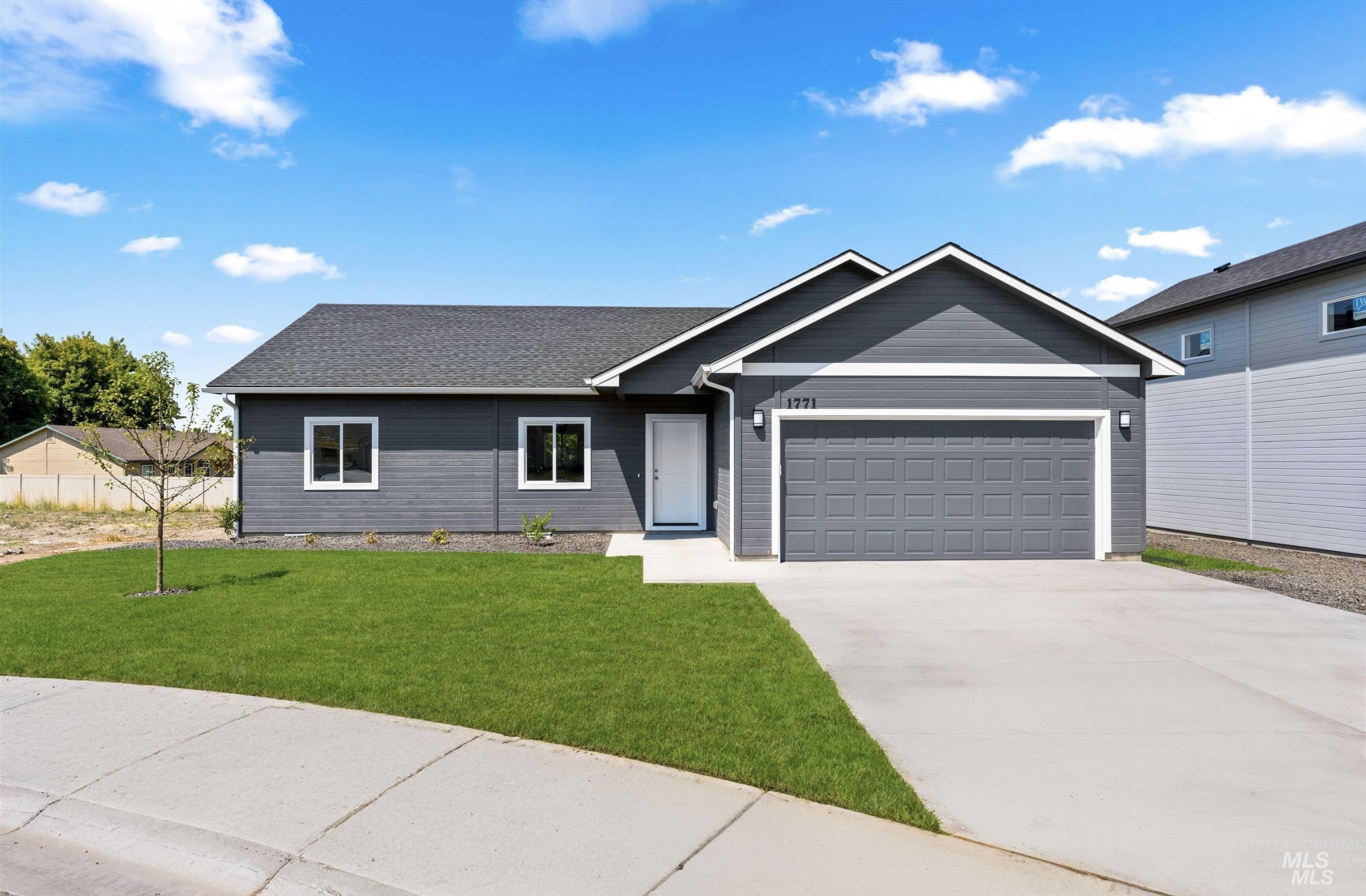 Ranch-style house featuring concrete driveway, a garage, a front lawn, and a shingled roof
